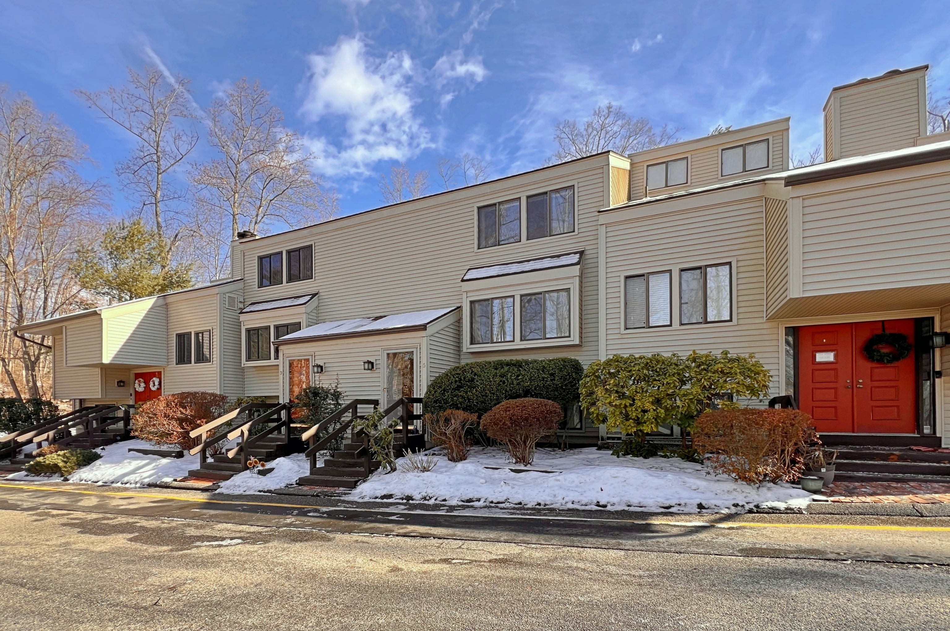 a front view of a house with a yard outdoor seating and covered with trees