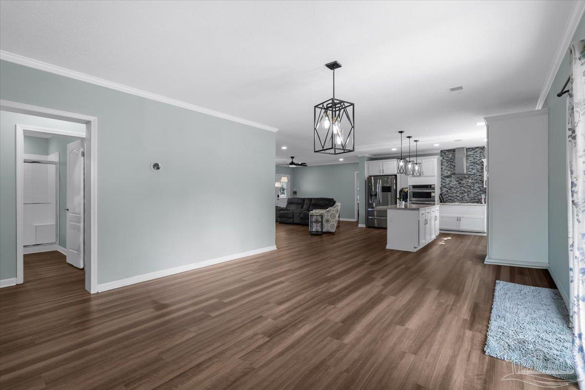 4955 Blue Ribbon Drive Milton, FL 32583 - Photo 6 of 32 a view of a living room and kitchen with wooden floor