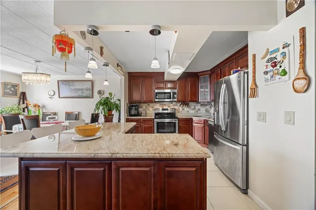 a kitchen with stainless steel appliances granite countertop wooden cabinets a stove top oven a sink and dishwasher
