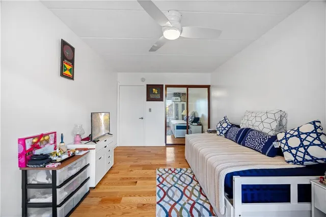 a spacious bedroom with a bed a couch and chandelier
