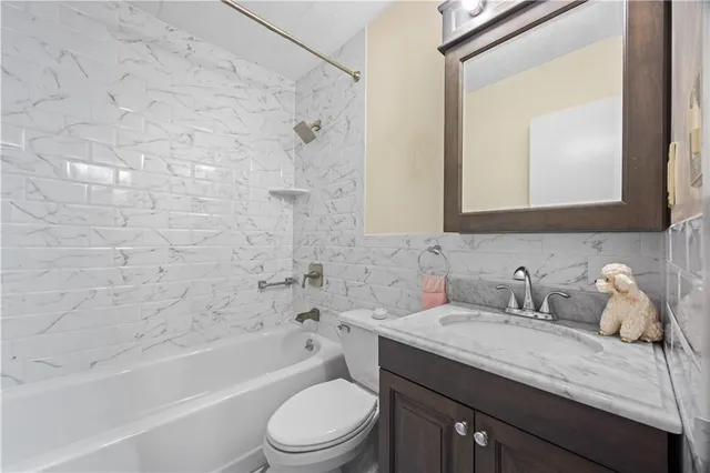 a bathroom with a granite countertop sink a toilet and bathtub