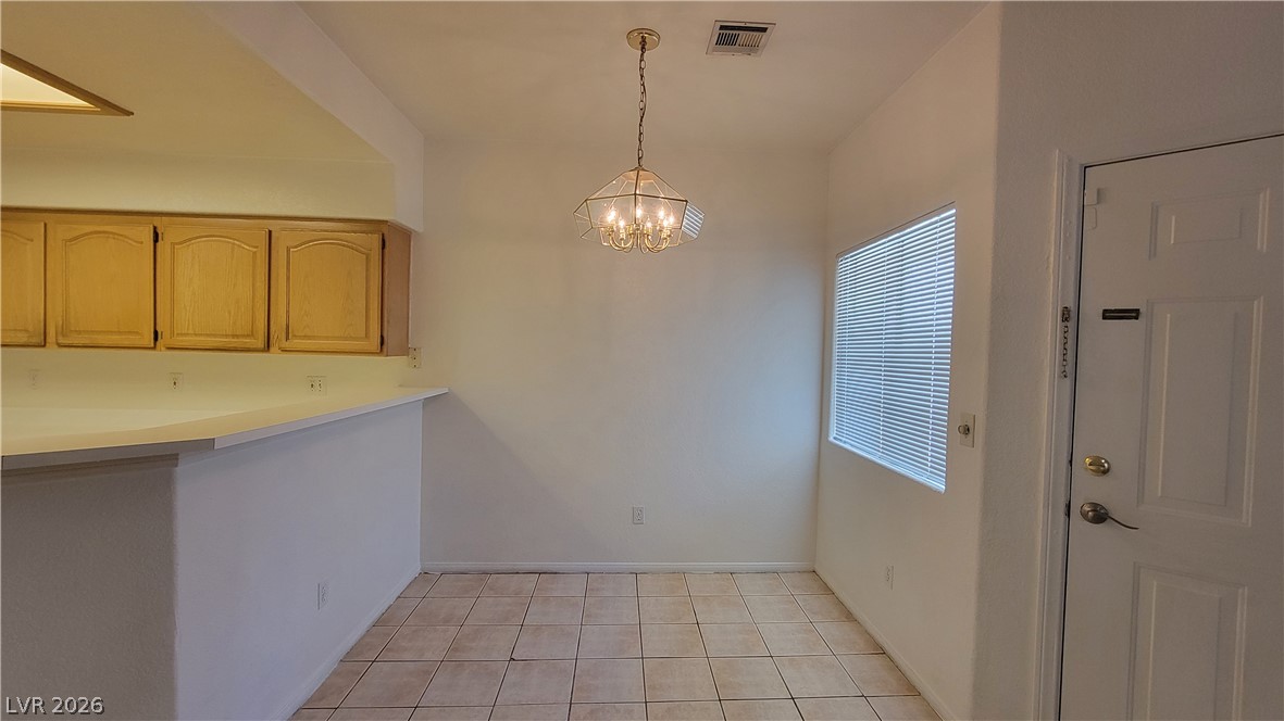 3320 South Fort Apache Road, Unit 111 Las Vegas, NV 89117 - Photo 3 of 12 A classic chandelier illuminates the tile flooring in this inviting dining area.