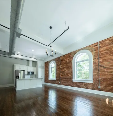 an open kitchen with a window and wooden floor