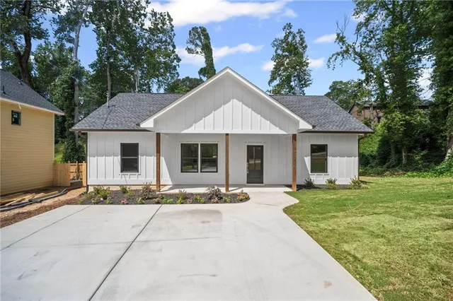 a front view of a house with a garden and trees