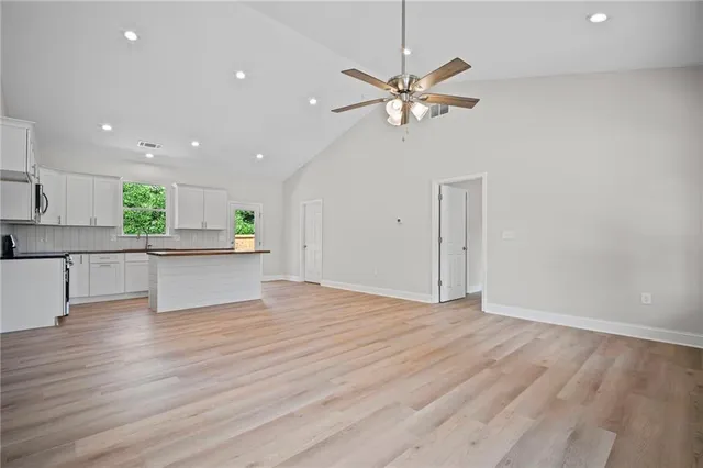 an empty room with a window and a fan