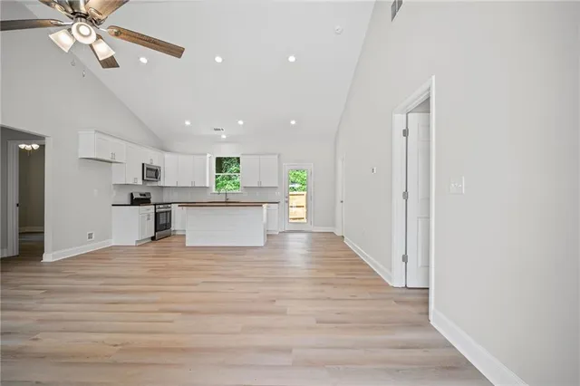 a view of a kitchen with a sink and an empty room