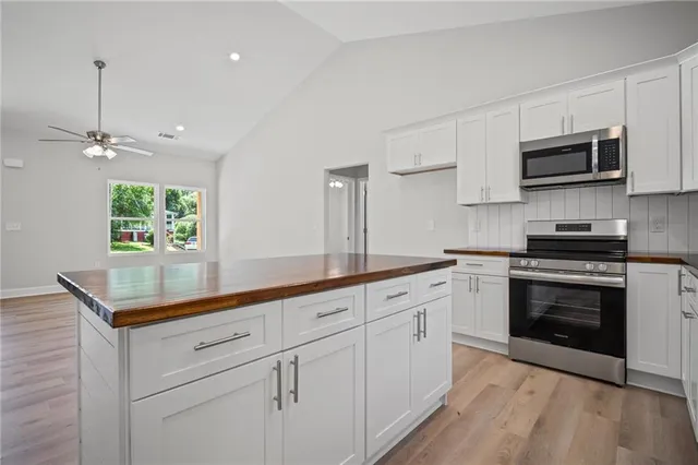 a kitchen with stainless steel appliances white cabinets and a sink