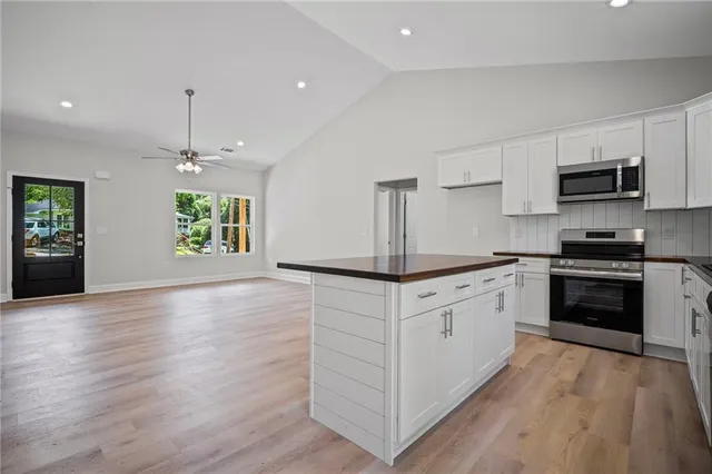 a kitchen with granite countertop white cabinets and white appliances