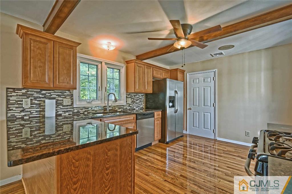 107 Brick Road Cherry Hill, NJ 08003 - Photo 8 of 18 a kitchen with stainless steel appliances granite countertop a refrigerator a sink dishwasher a stove and white cabinets with wooden floor