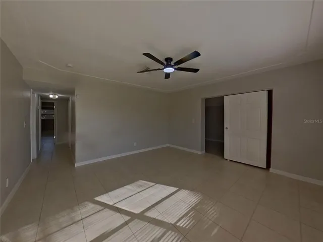 a view of an empty room with a ceiling fan