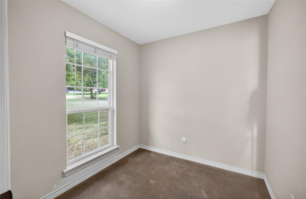 505 East 5th Street Springtown, TX 76082 - Photo 32 of 39 an empty room with wooden floor and windows