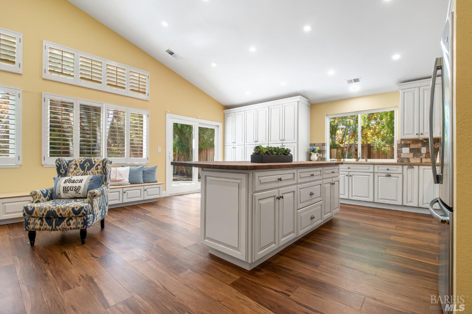 a kitchen with stainless steel appliances granite countertop wooden floors and white cabinets