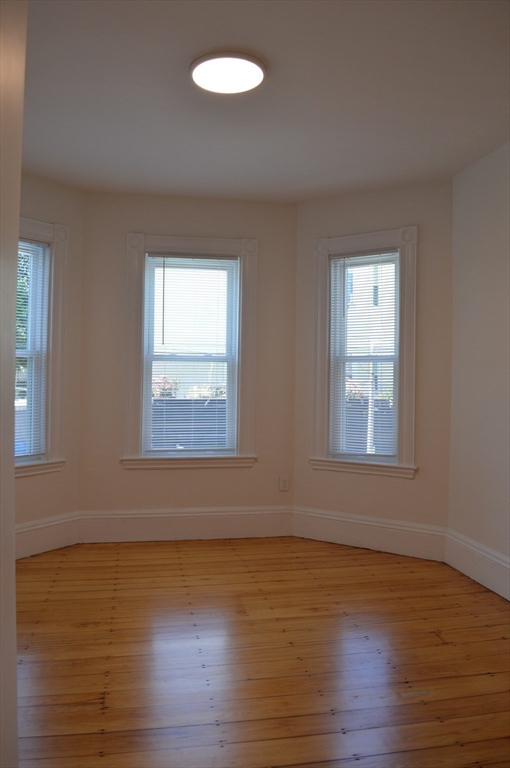 374 A Centre Street, Unit 3 Boston, MA 02130 - Photo 10 of 11 a view of an empty room with wooden floor and a window