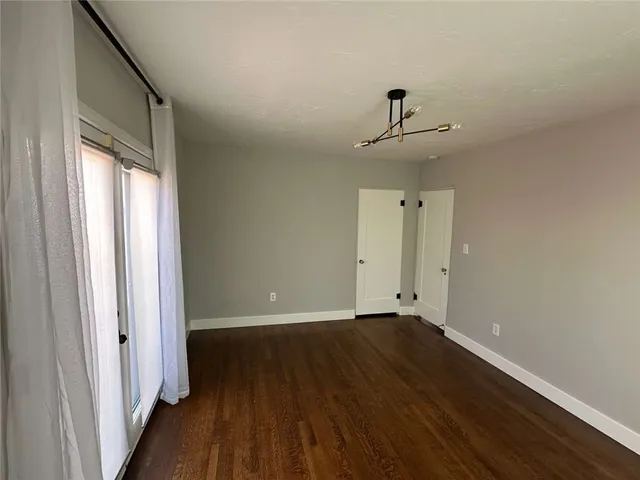 a view of room with window ceiling fan and hardwood floor
