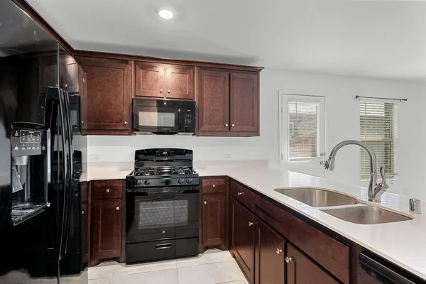 a kitchen with granite countertop a sink stainless steel appliances and cabinets