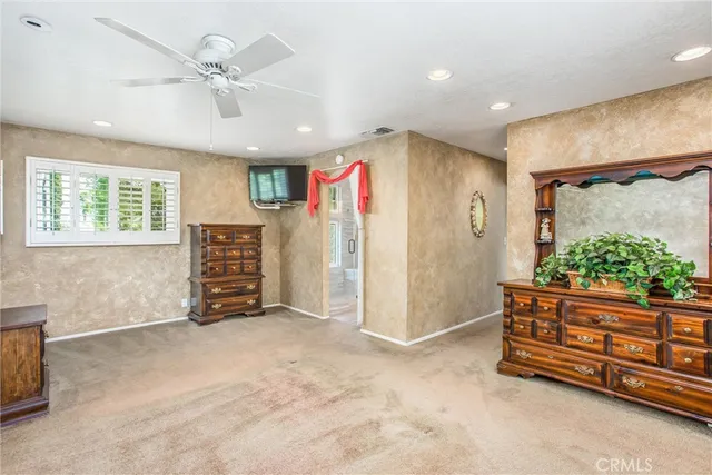 an empty room with windows and ceiling fan