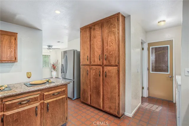 a kitchen with stainless steel appliances granite countertop a refrigerator and a stove top oven