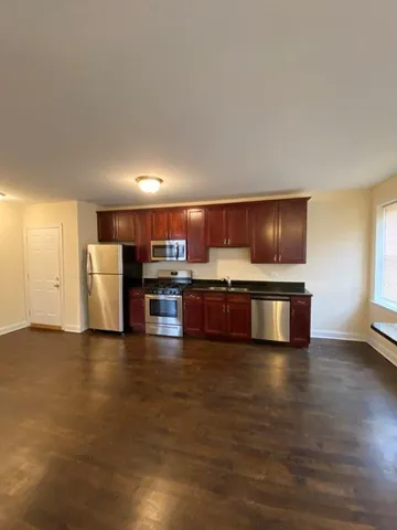 a view of kitchen with refrigerator stove microwave and cabinets