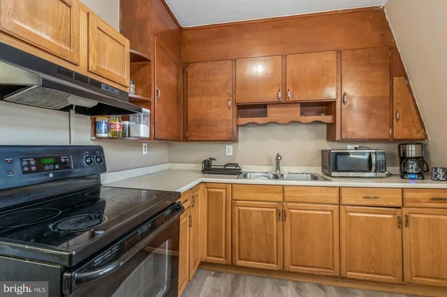 a kitchen with stainless steel appliances granite countertop a sink stove and cabinets