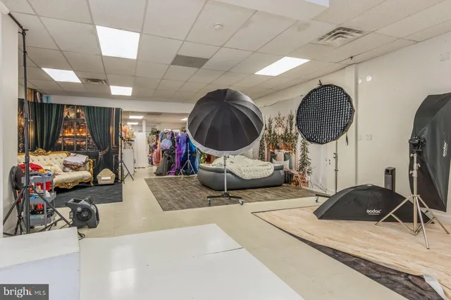 a room with lots of white furniture and gym equipment