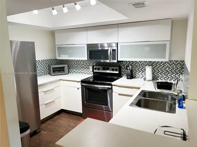 a kitchen with stainless steel appliances a stove a microwave and a refrigerator