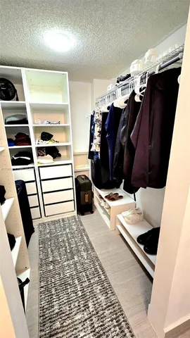 a view of walk in closet with clothes and shoes