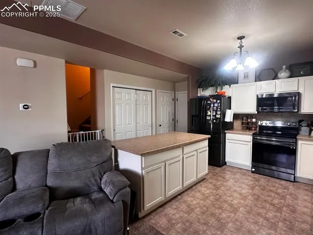 a kitchen with stainless steel appliances granite countertop a stove and a refrigerator