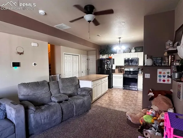 a living room with furniture and kitchen view