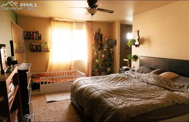 a bedroom with a bed and a flat tv screen on dresser