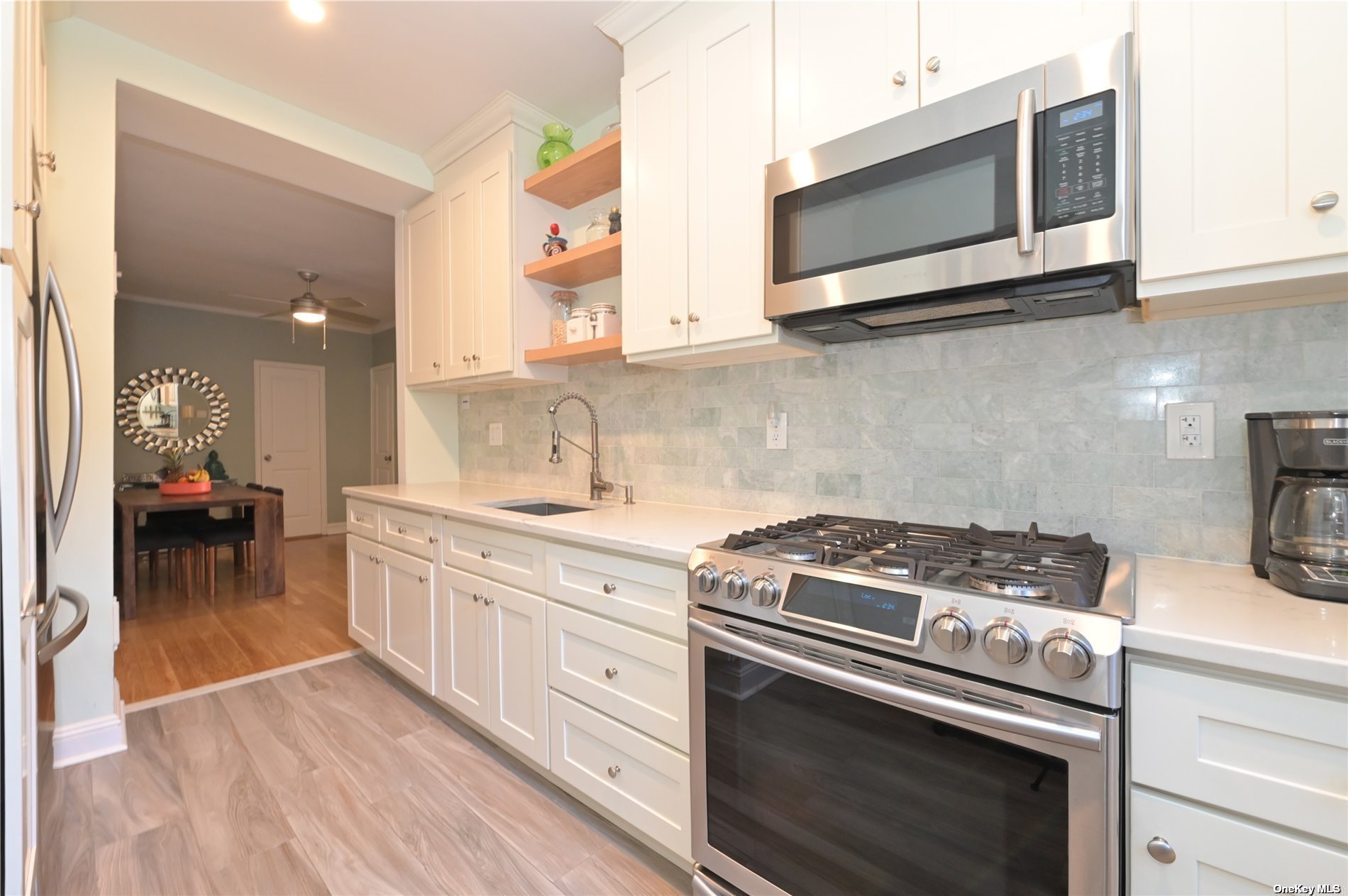 a kitchen with stainless steel appliances a stove a microwave a sink and cabinets