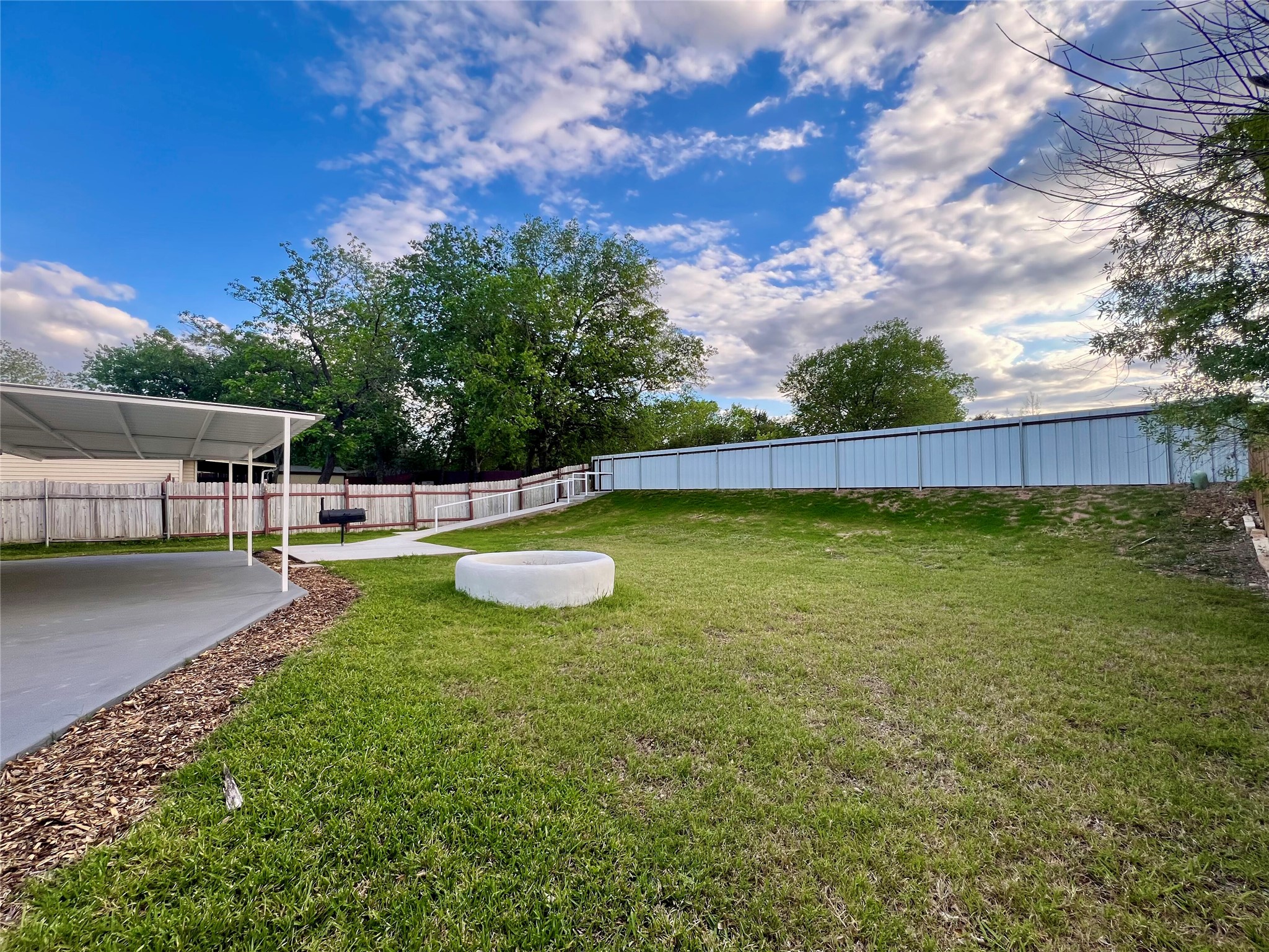 8007 Colony Loop Drive Austin, TX 78724 - Photo 10 of 40 Large backyard with covered patio, open lawn, and built-in fire pit designed for entertaining and everyday outdoor living. Privacy fence recently installed.