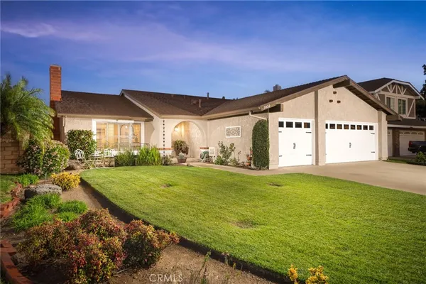 a view of a big house with a big yard and potted plants