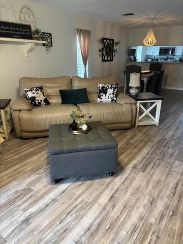 a living room with furniture window and wooden floor