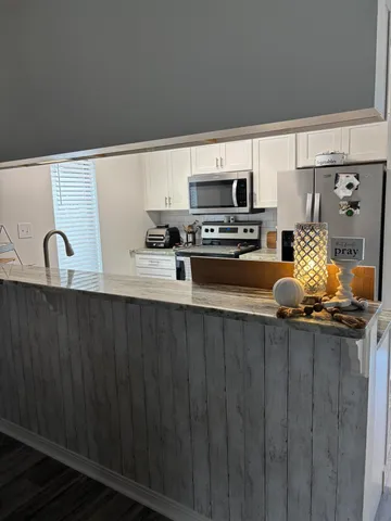 a kitchen with stainless steel appliances a sink a stove a microwave and wooden cabinets