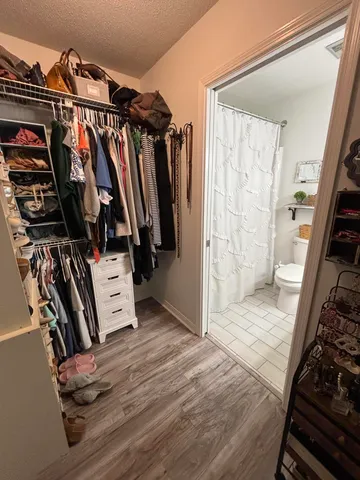 a view of walk in closet with clothes and shoes