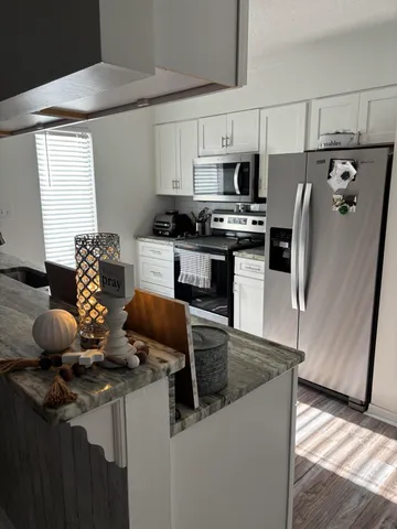 a kitchen with stainless steel appliances granite countertop a sink a stove and a refrigerator