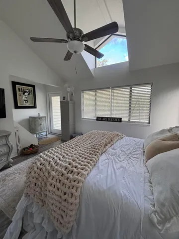 a bedroom with a bed and a large window