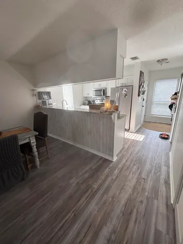 a kitchen with a wooden floor and furniture