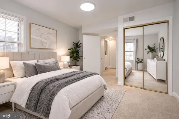 a spacious bedroom with a large bed and a chandelier