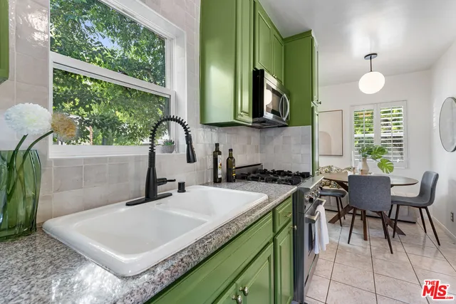 a kitchen that has a sink a table and chairs in it