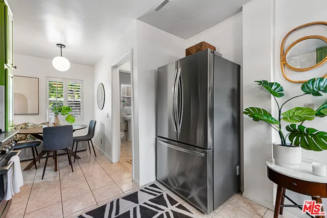 a kitchen with a refrigerator and wooden floor