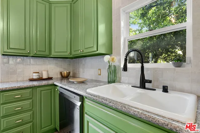 a kitchen with a sink a counter top and a wooden floors