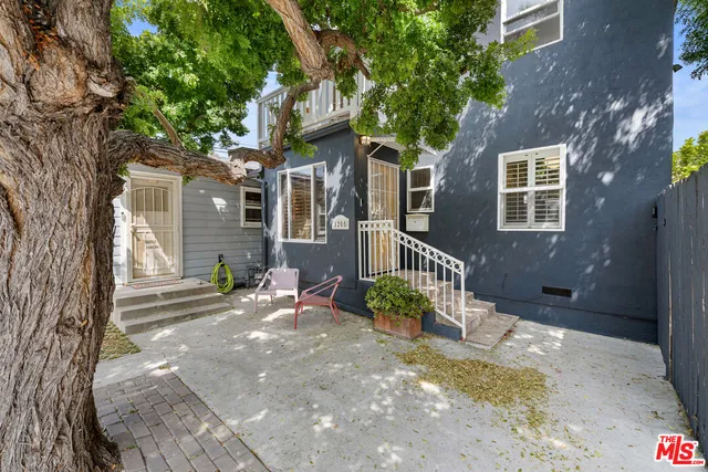 a front view of a house with a tree