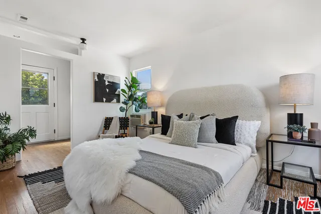 a bedroom with a bed and painting on the wall