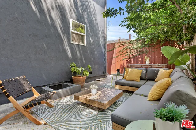 a outdoor sitting area with chairs and wooden fence