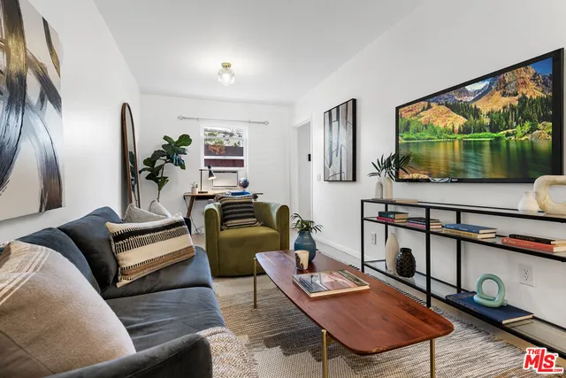 a living room with furniture a flat screen tv and a floor to ceiling window
