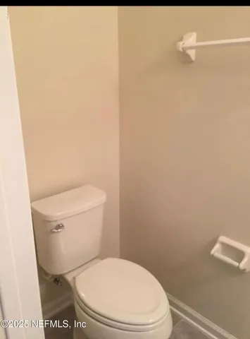 a white toilet sitting next to a white wall