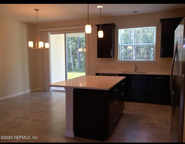 a kitchen with a sink window and cabinets