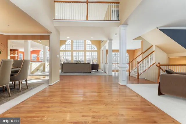 a kitchen with stainless steel appliances kitchen island granite countertop a table chairs in it and wooden floors