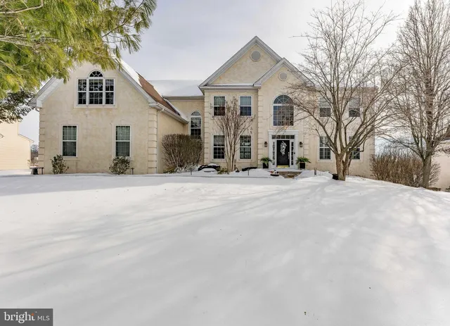 a view of a white house with a yard covered in snow